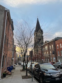 a car parked on a street with a clock tower in the background